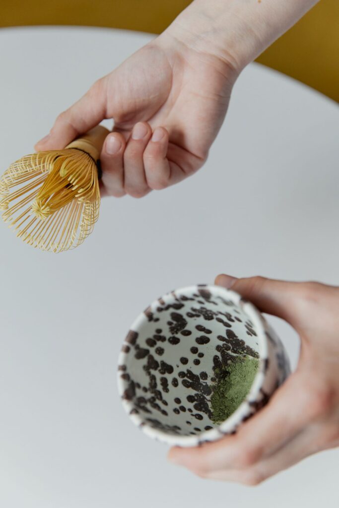Matcha voor kinderen: matchapoeder in een kom met bamboe klopper